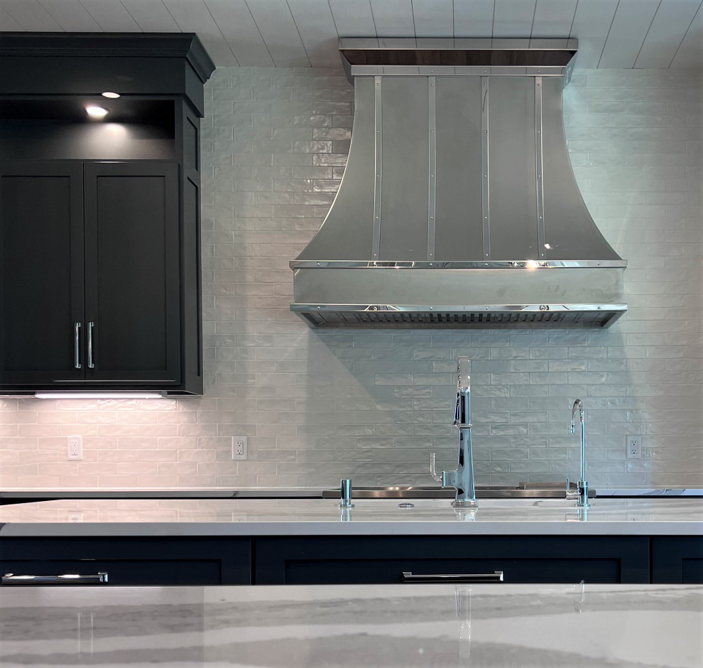 Example of a large transitional kitchen design with an undermount sink, shaker cabinets, gray cabinets, quartz countertops, white backsplash, stainless steel appliances, two islands and white countertops