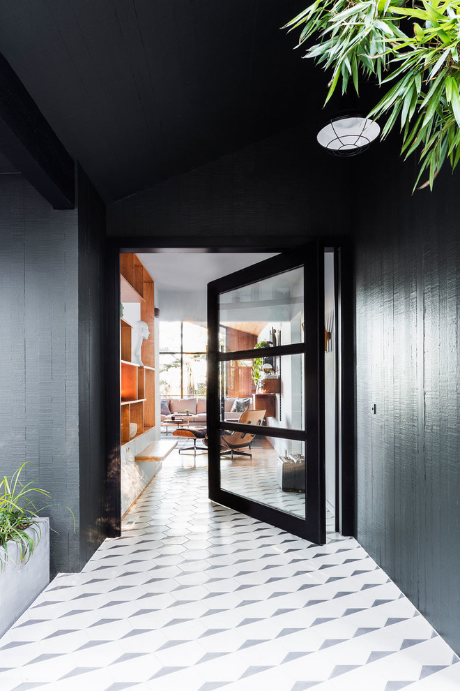 Large midcentury front door in Portland with a pivot front door, a glass front door, black walls, porcelain floors and white floor.