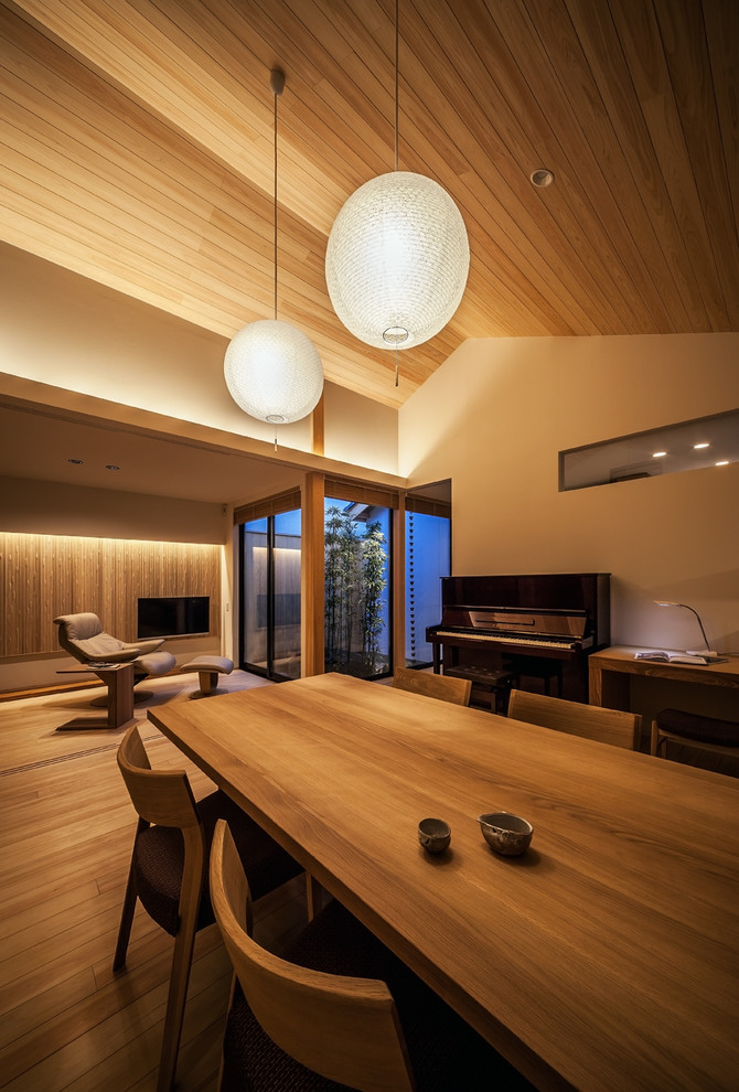 Inspiration for an asian open plan dining in Kobe with white walls, medium hardwood floors and brown floor.