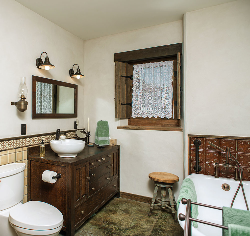 Photo of a mid-sized traditional master bathroom in San Diego with furniture-like cabinets, brown cabinets, a claw-foot tub, a corner shower, a two-piece toilet, beige tile, ceramic tile, white walls, concrete floors, a vessel sink, wood benchtops, multi-coloured floor and a shower curtain.