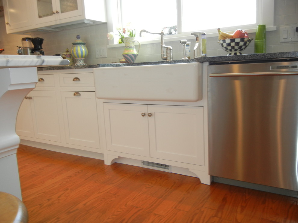 Example of a large transitional u-shaped medium tone wood floor, brown floor and shiplap ceiling open concept kitchen design with a farmhouse sink, shaker cabinets, white cabinets, granite countertops, subway tile backsplash, stainless steel appliances, an island, white backsplash and gray countertops
