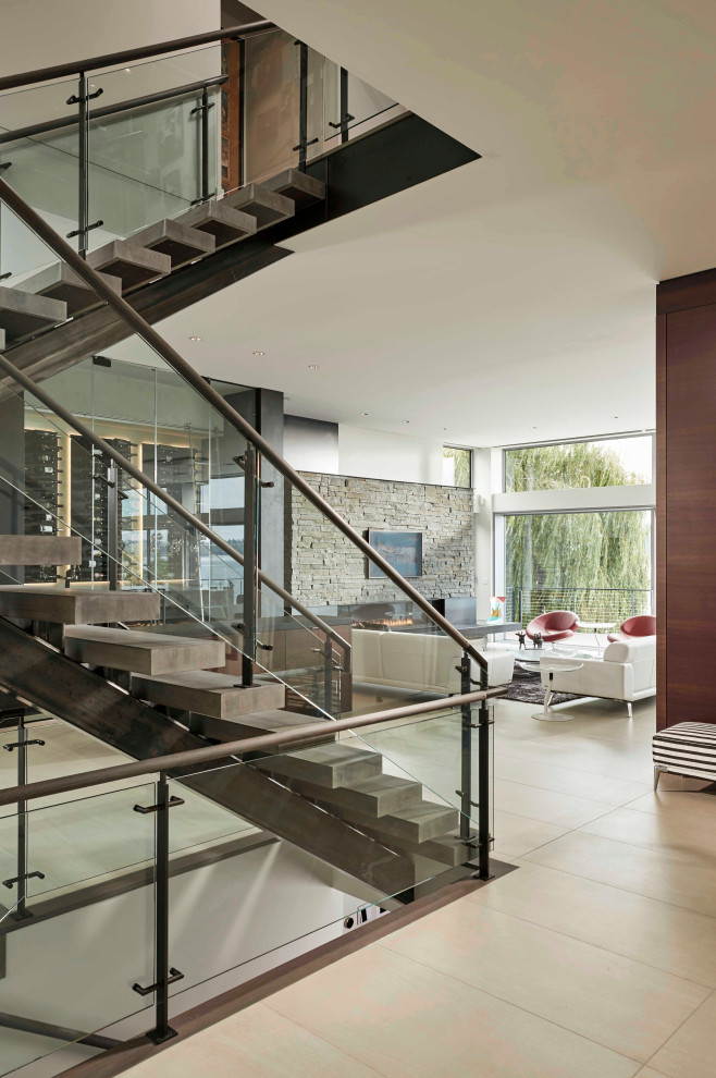 Photo of a mid-sized modern concrete floating staircase in Seattle with open risers and glass railing.