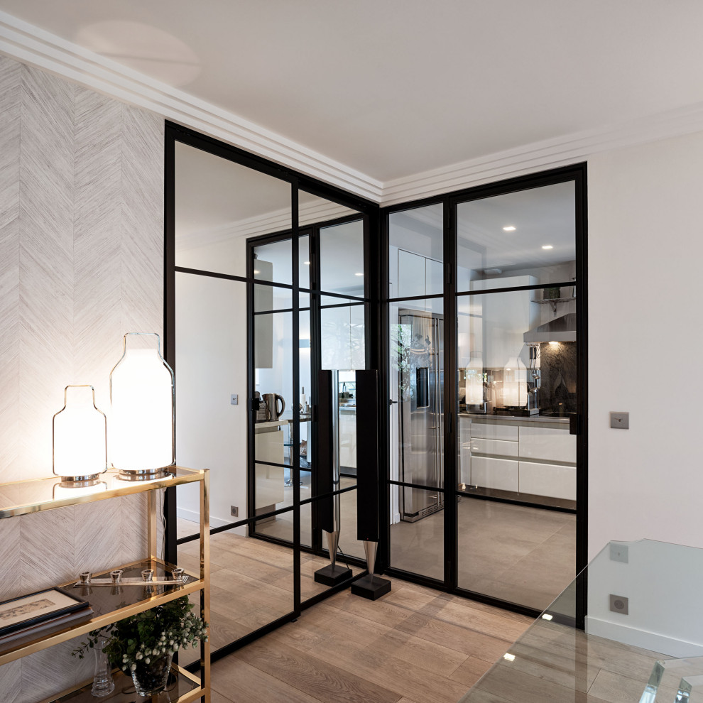 Medium sized modern open plan dining room in Paris with white walls, medium hardwood flooring and wallpapered walls.