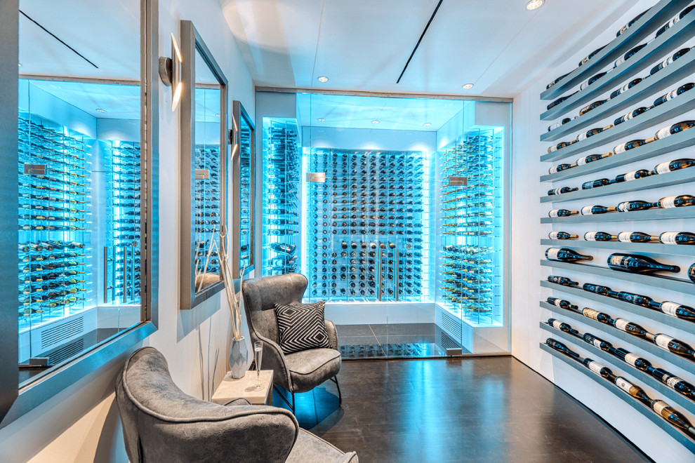 This is an example of an expansive modern wine cellar in Portland with ceramic flooring, display racks and black floors.
