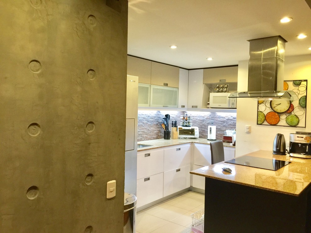 Photo of a small contemporary u-shaped kitchen in Other with a drop-in sink, recessed-panel cabinets, white cabinets, granite benchtops, beige splashback, stone tile splashback, black appliances, porcelain floors and a peninsula.