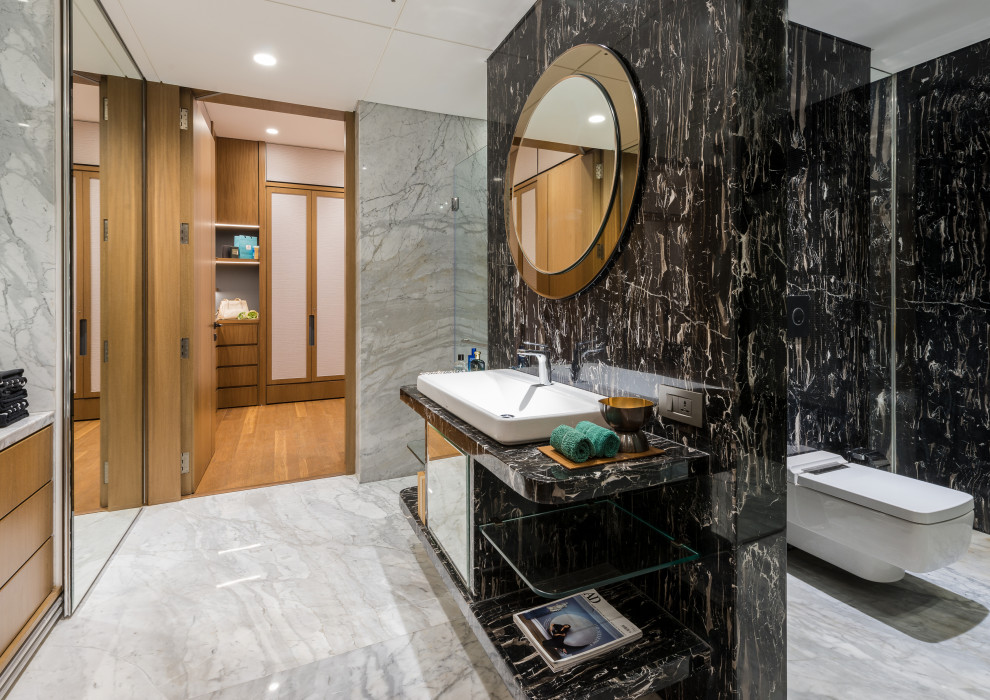Inspiration for a contemporary bathroom in Mumbai with a wall-mount toilet, black tile, stone slab, a vessel sink, white floor and black benchtops.