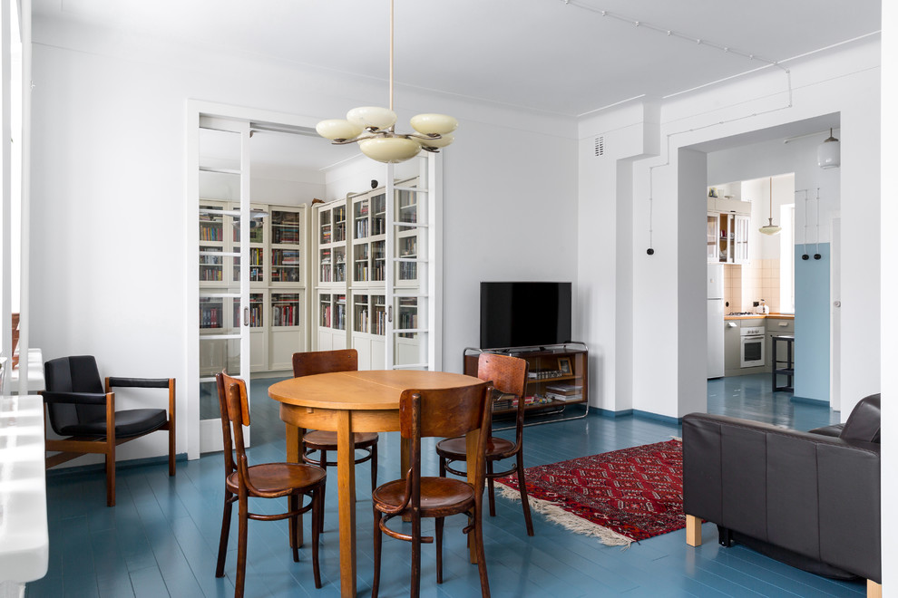 Пример оригинального дизайна: гостиная комната в стиле ретро с белыми стенами, деревянным полом и синим полом