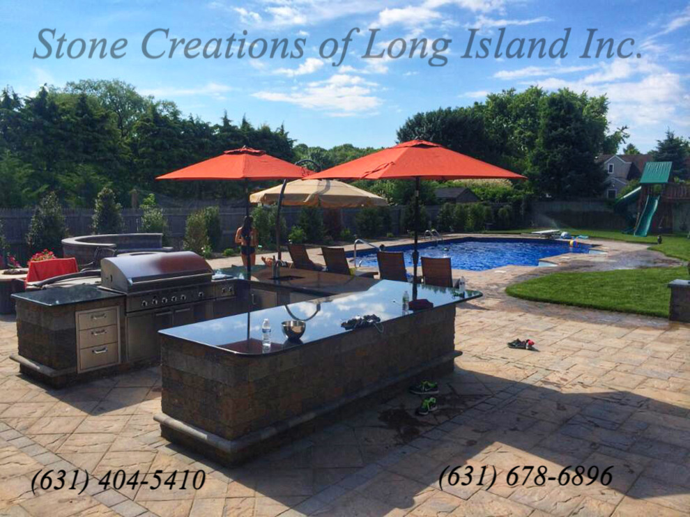 This is an example of a large contemporary backyard patio in New York with an outdoor kitchen, concrete pavers and no cover.