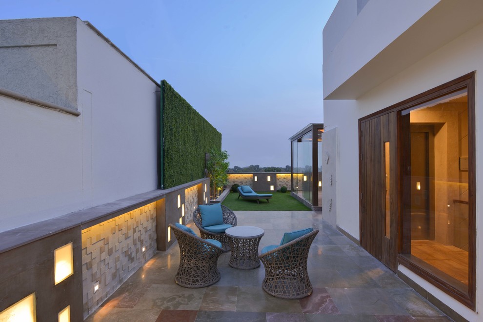Photo of a mid-sized contemporary rooftop partial sun garden in Delhi with concrete pavers.