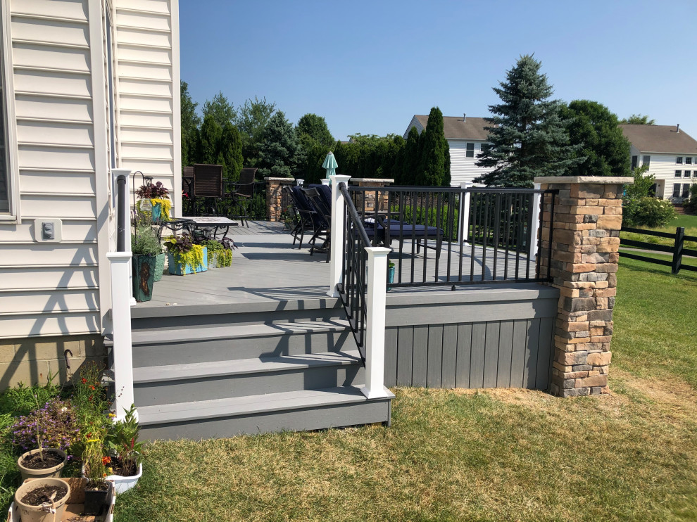 This is an example of an expansive eclectic backyard deck in Columbus with with skirting and metal railing.
