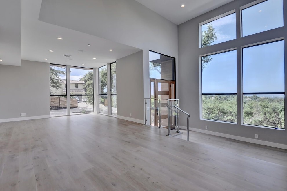 Photo of a mid-sized contemporary open concept living room in San Francisco with grey walls, light hardwood floors and grey floor.