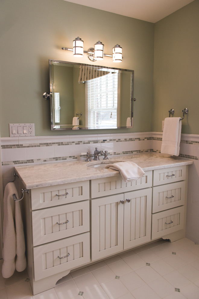 Photo of a large transitional kids bathroom in New York with beaded inset cabinets, white cabinets, white tile, ceramic tile, green walls, porcelain floors, an undermount sink, engineered quartz benchtops and white floor.
