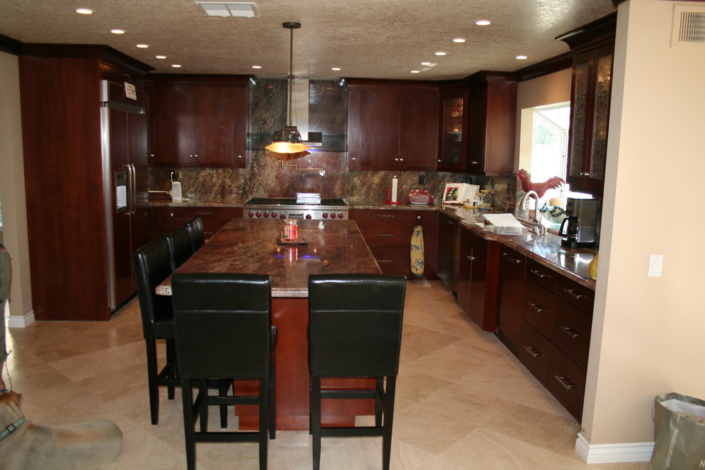 Large transitional u-shaped kitchen photo in Orange County with raised-panel cabinets, dark wood cabinets and stainless steel appliances