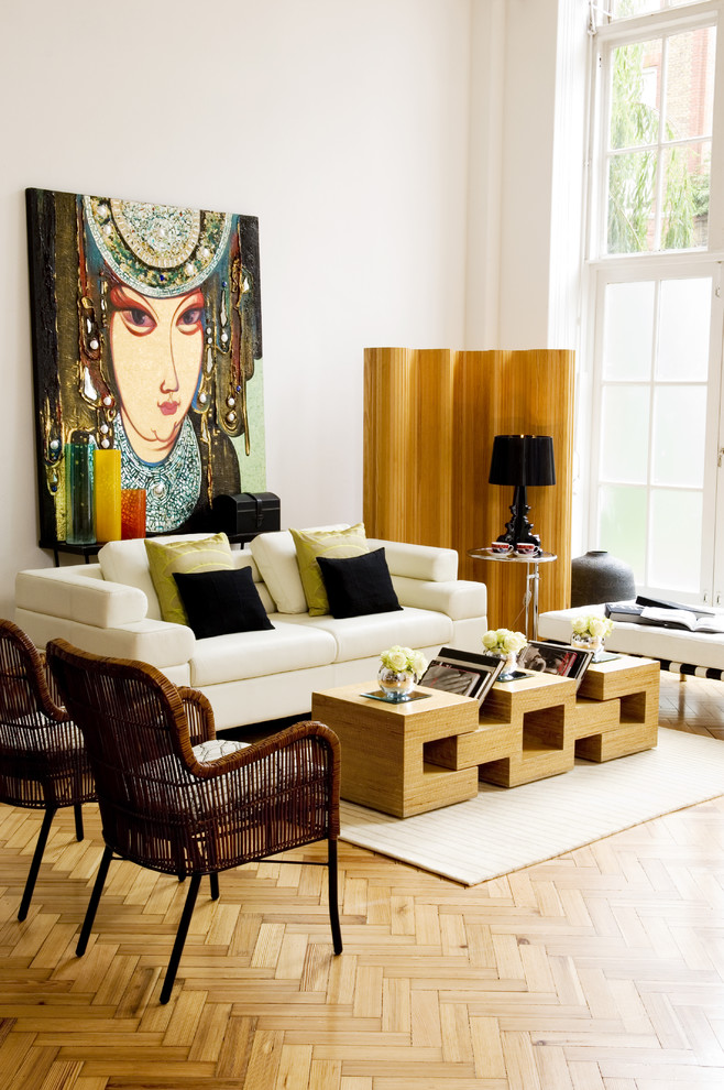 Eclectic living room in London with white walls and medium hardwood floors.