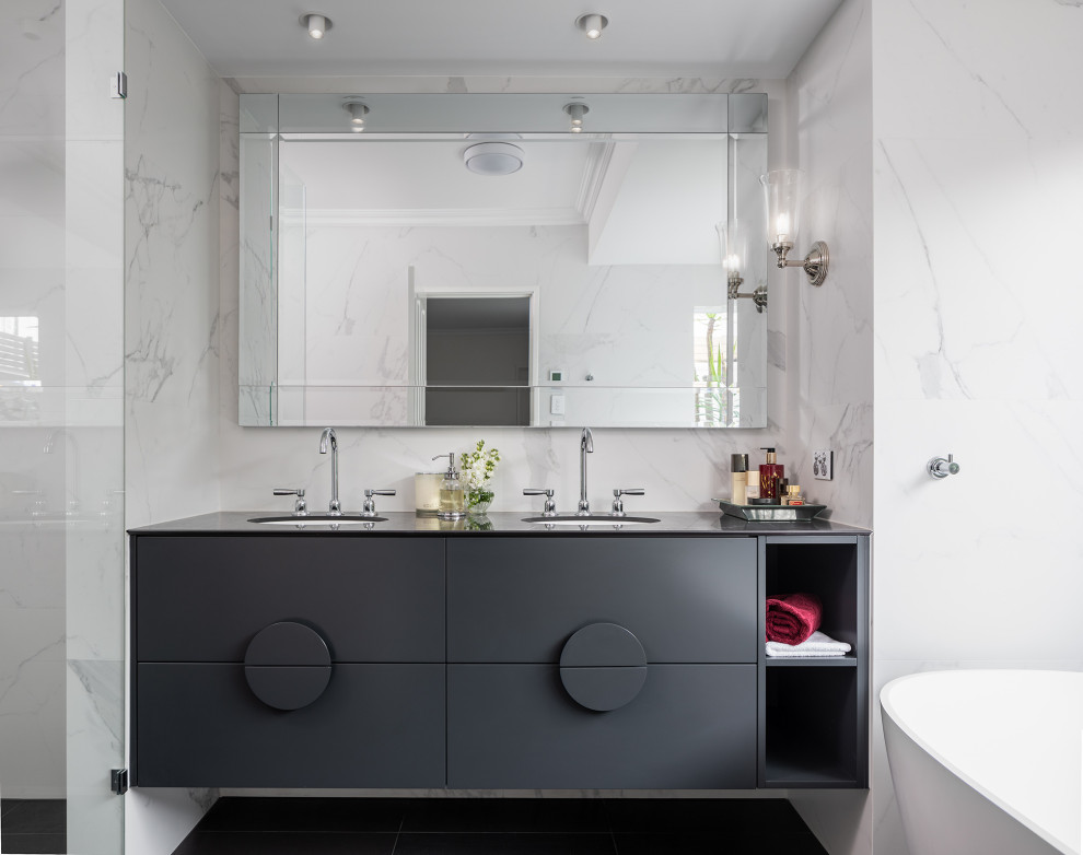 Design ideas for a mid-sized contemporary master bathroom in Perth with black cabinets, a freestanding tub, a one-piece toilet, porcelain tile, an undermount sink, tile benchtops, black floor, black benchtops, a double vanity, a floating vanity, a niche and recessed.