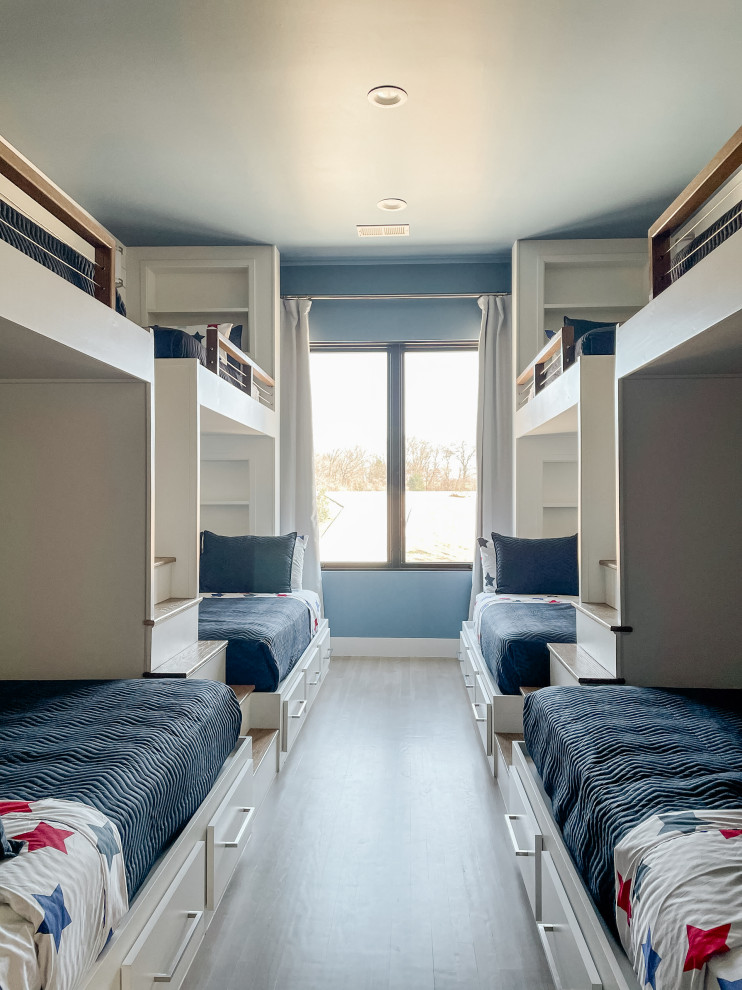 This is an example of a large contemporary guest bedroom in Dallas with blue walls, light hardwood floors, beige floor and planked wall panelling.