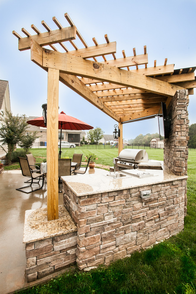 Mid-sized arts and crafts backyard patio in Charlotte with an outdoor kitchen, concrete slab and a pergola.