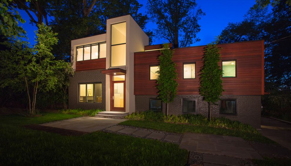 This is an example of a large contemporary two-storey brown house exterior in DC Metro with mixed siding and a flat roof.
