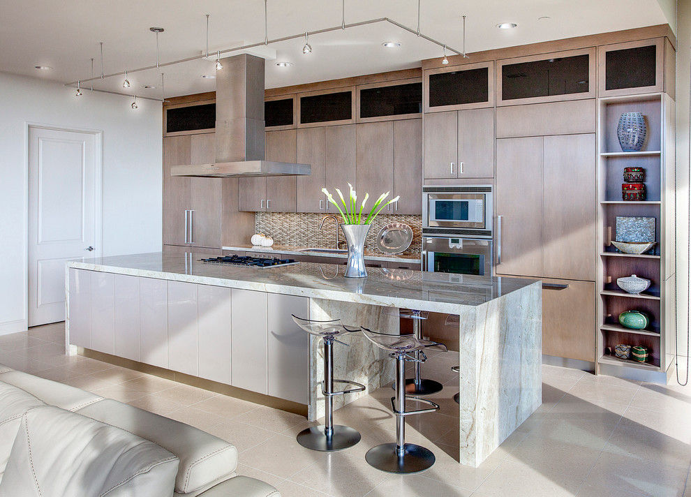 This is an example of a large contemporary single-wall open plan kitchen in Houston with an undermount sink, flat-panel cabinets, stainless steel appliances, beige splashback, with island, beige cabinets and white floor.