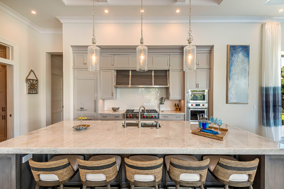Beach style medium tone wood floor open concept kitchen photo with stainless steel appliances and an island
