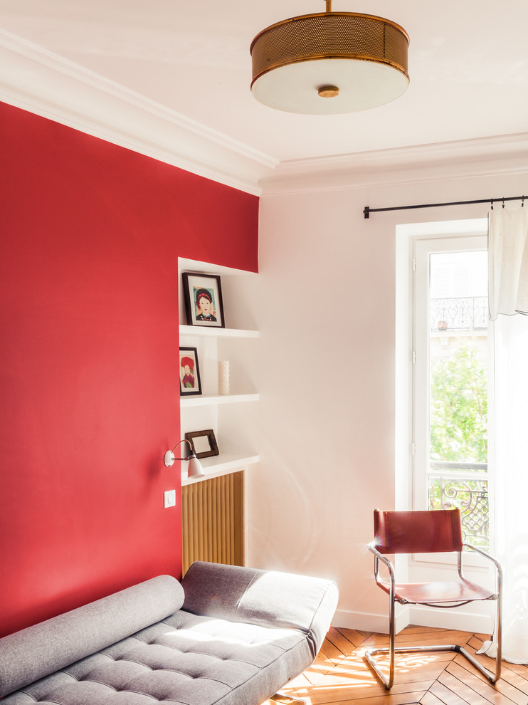 Photo of a small midcentury guest bedroom in Paris with red walls and medium hardwood flooring.