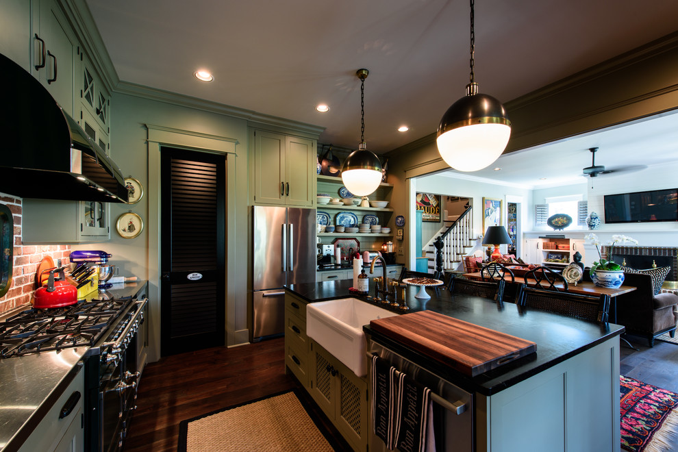 This is an example of an eclectic kitchen in Nashville with a farmhouse sink, shaker cabinets, green cabinets, soapstone benchtops, dark hardwood floors and with island.