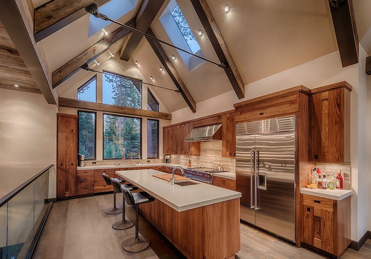 Inspiration for a large arts and crafts l-shaped kitchen in San Francisco with shaker cabinets, medium wood cabinets, stainless steel appliances, with island and brown floor.
