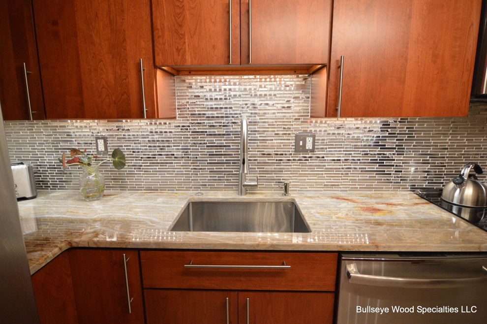 This is an example of a small transitional l-shaped separate kitchen in DC Metro with an undermount sink, flat-panel cabinets, medium wood cabinets, quartzite benchtops, grey splashback, metal splashback, stainless steel appliances and terra-cotta floors.