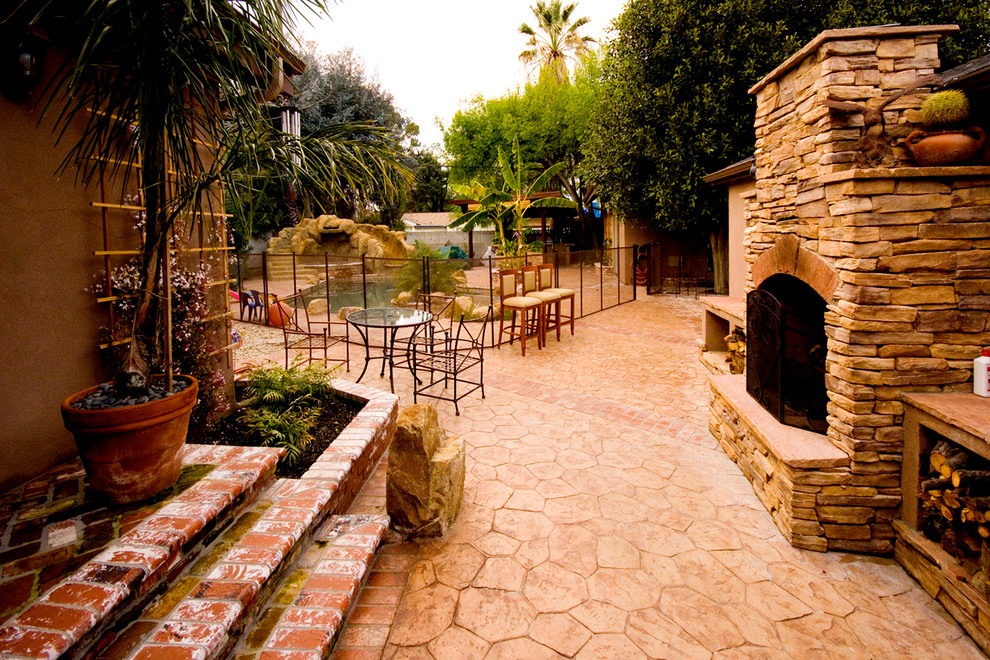 Design ideas for a mid-sized mediterranean backyard patio in Los Angeles with a fire feature, natural stone pavers and no cover.