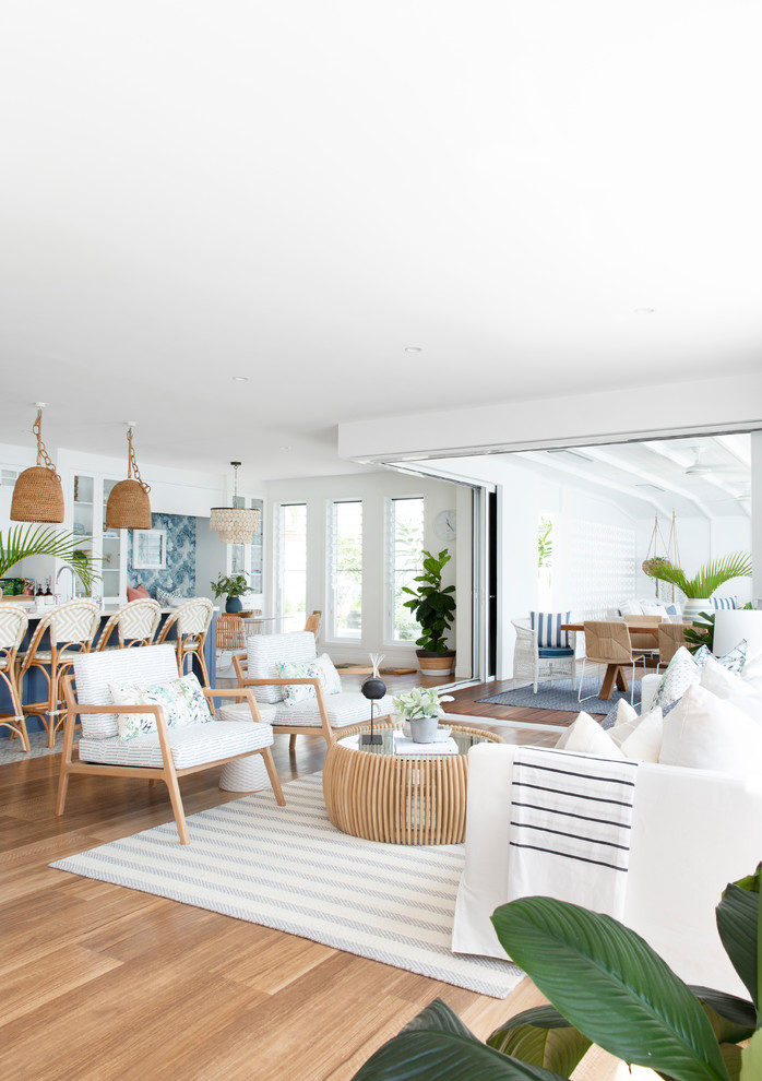 Inspiration for an expansive beach style open concept living room in Gold Coast - Tweed with white walls, vinyl floors, no tv and brown floor.
