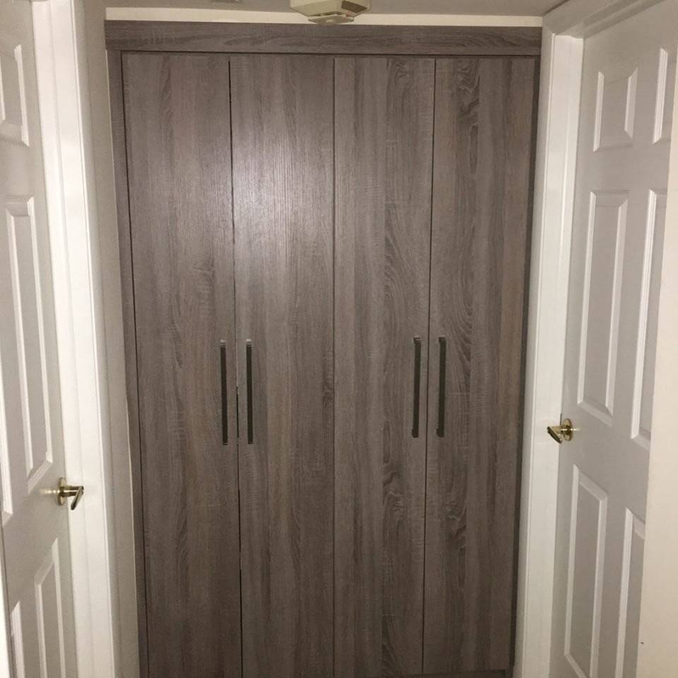 Inspiration for a mid-sized contemporary men's built-in wardrobe in Miami with flat-panel cabinets, medium wood cabinets, ceramic floors and beige floor.