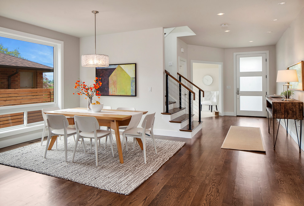 Design ideas for a contemporary dining room in Seattle with white walls and dark hardwood floors.