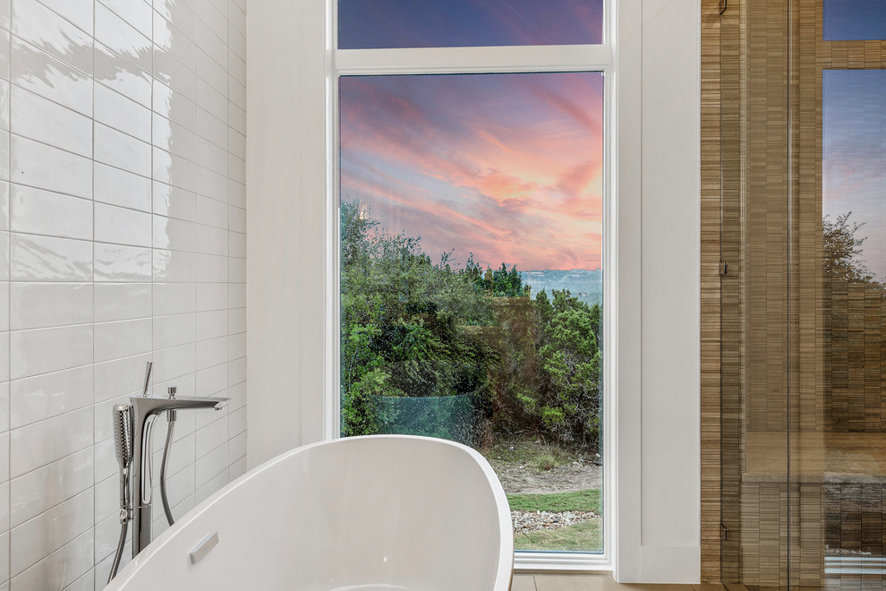 Design ideas for a large contemporary master bathroom in Austin with flat-panel cabinets, medium wood cabinets, a freestanding tub, white tile, ceramic tile, white walls, porcelain floors, an undermount sink, beige floor and a hinged shower door.