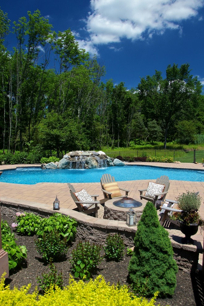 Inspiration for a mid-sized country backyard custom-shaped pool in New York with a water feature and brick pavers.