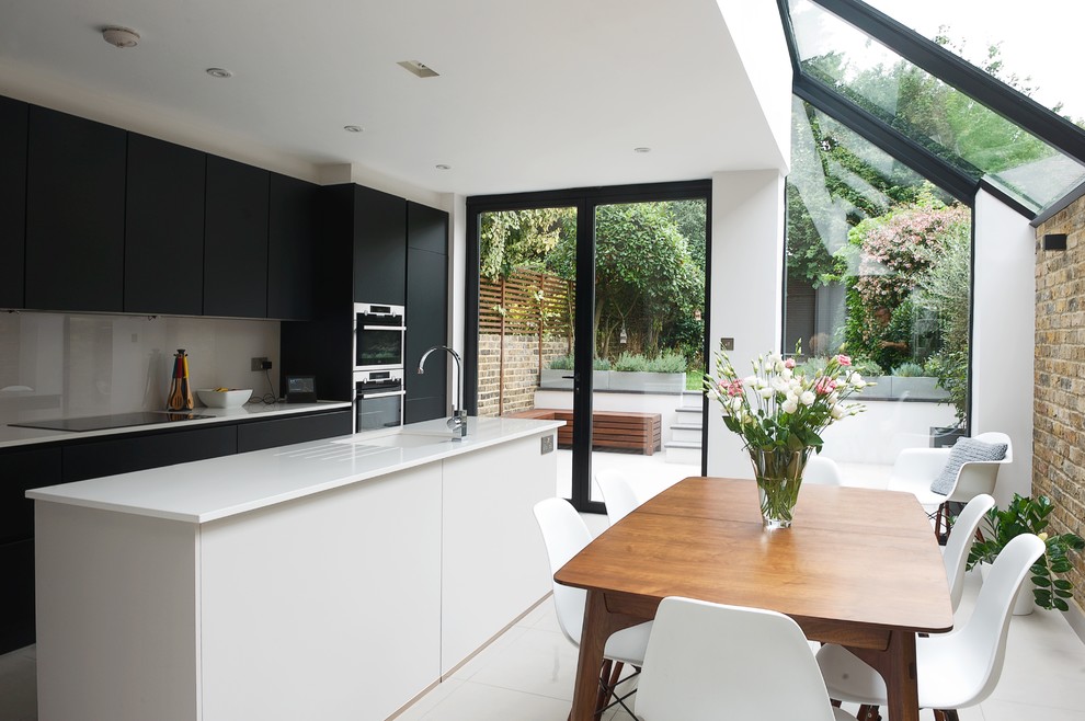 Inspiration for a contemporary kitchen/dining combo in London with white walls and white floor.