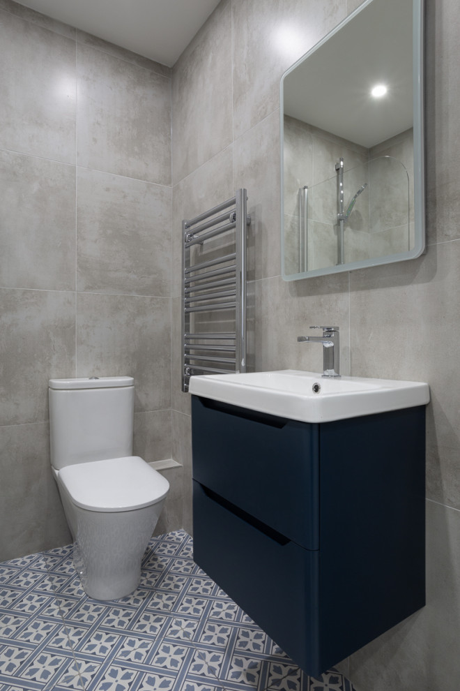Идея дизайна: детская ванная комната в современном стиле с плоскими фасадами, синими фасадами, ванной в нише, душем в нише, унитазом-моноблоком, зеленой плиткой, полом из керамической плитки, консольной раковиной, синим полом, душем с распашными дверями, тумбой под одну раковину и подвесной тумбой