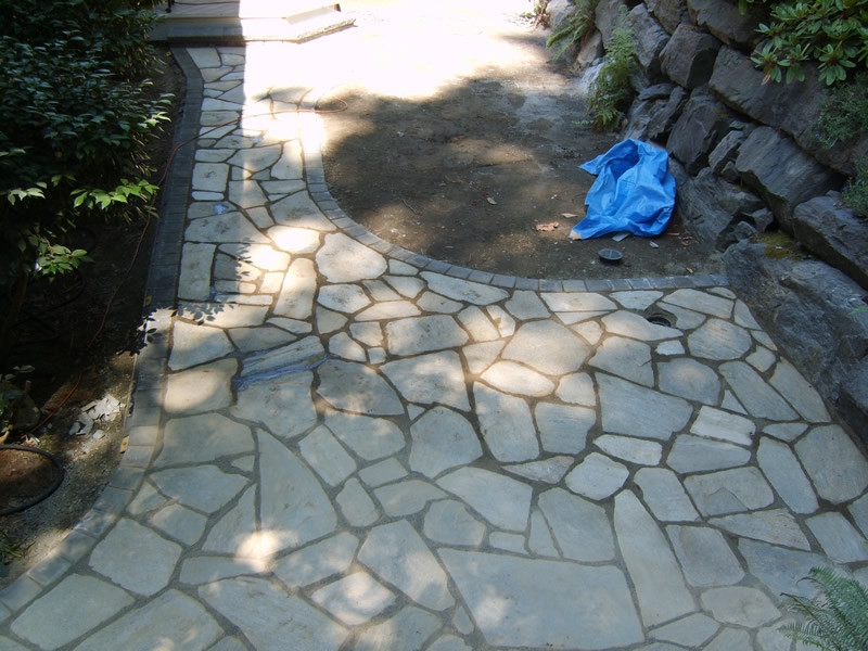 Mid-sized elegant backyard stone patio photo in Seattle