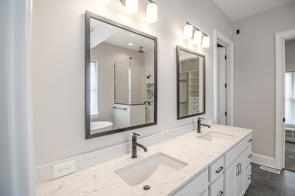 Expansive traditional ensuite bathroom in Cleveland with recessed-panel cabinets, white cabinets, a freestanding bath, a corner shower, grey walls, medium hardwood flooring, a built-in sink, grey floors, a hinged door, white worktops, a laundry area, double sinks and a floating vanity unit.