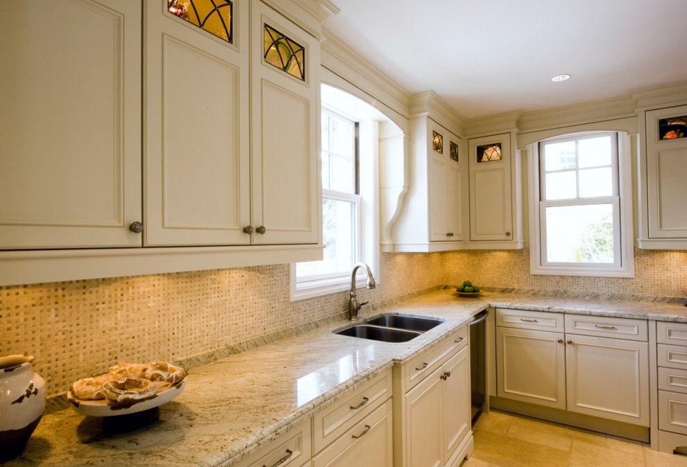 Example of a mid-sized transitional u-shaped travertine floor and beige floor enclosed kitchen design in Toronto with an undermount sink, recessed-panel cabinets, beige cabinets, granite countertops, multicolored backsplash, marble backsplash, stainless steel appliances, no island and multicolored countertops