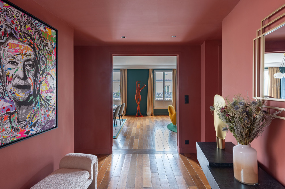 Großer Moderner Flur mit roter Wandfarbe, dunklem Holzboden und braunem Boden in Paris