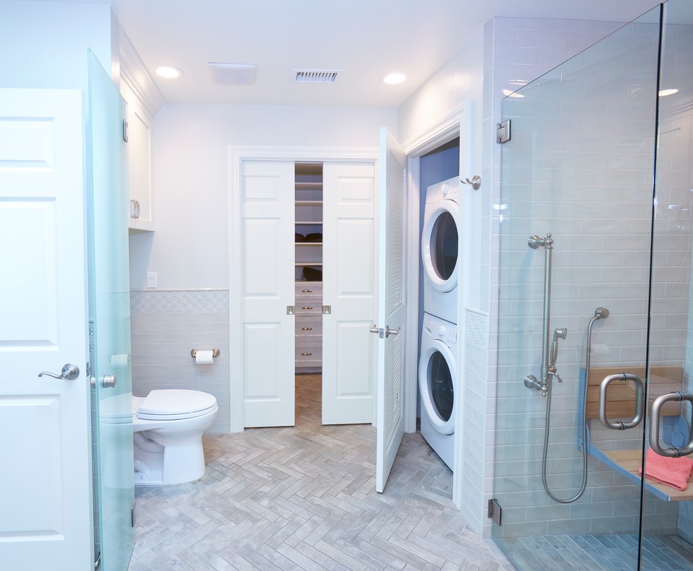 Inspiration for a mid-sized arts and crafts master bathroom in San Diego with shaker cabinets, white cabinets, a curbless shower, a one-piece toilet, gray tile, ceramic tile, grey walls, ceramic floors, an undermount sink, engineered quartz benchtops, grey floor, a hinged shower door and white benchtops.