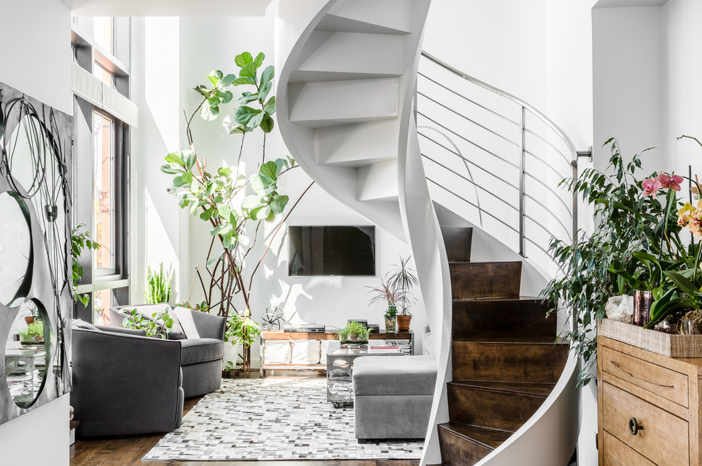 Photo of a mid-sized contemporary wood curved staircase in New York with metal risers.