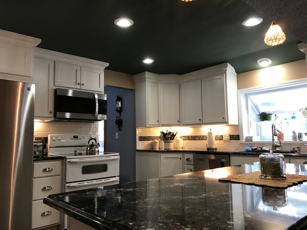 Eat-in kitchen - mid-sized transitional u-shaped medium tone wood floor eat-in kitchen idea in New York with a double-bowl sink, shaker cabinets, white cabinets, granite countertops, white backsplash, subway tile backsplash and stainless steel appliances