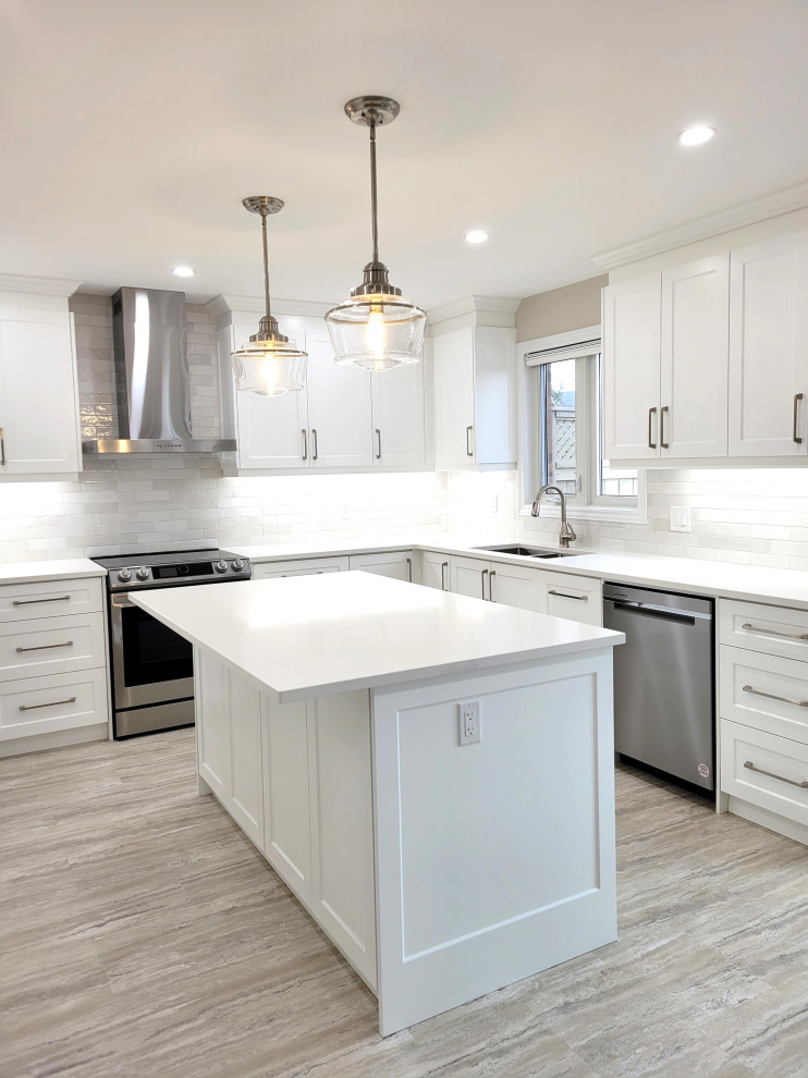 Example of a huge transitional u-shaped vinyl floor eat-in kitchen design with an undermount sink, white cabinets, quartzite countertops, gray backsplash, stone tile backsplash, stainless steel appliances, an island and white countertops