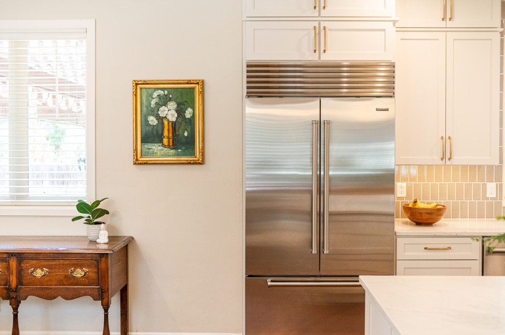 Open concept kitchen - large transitional l-shaped dark wood floor and brown floor open concept kitchen idea in Denver with a farmhouse sink, shaker cabinets, beige cabinets, quartz countertops, beige backsplash, ceramic backsplash, stainless steel appliances, an island and white countertops