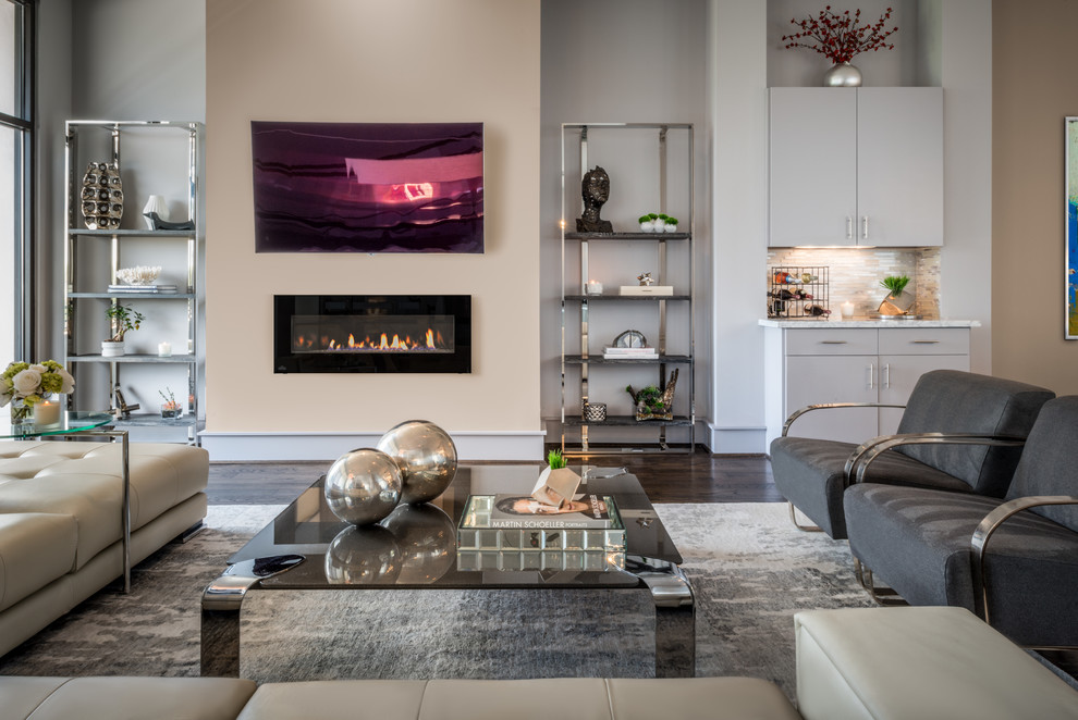 Design ideas for a large modern open concept living room in Houston with a home bar, grey walls, dark hardwood floors, a hanging fireplace and a wall-mounted tv.