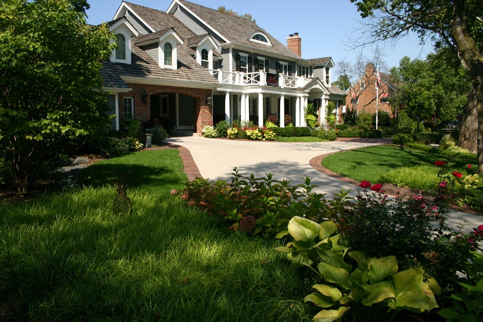 Expansive traditional front yard partial sun driveway in Chicago with brick pavers and a garden path for summer.