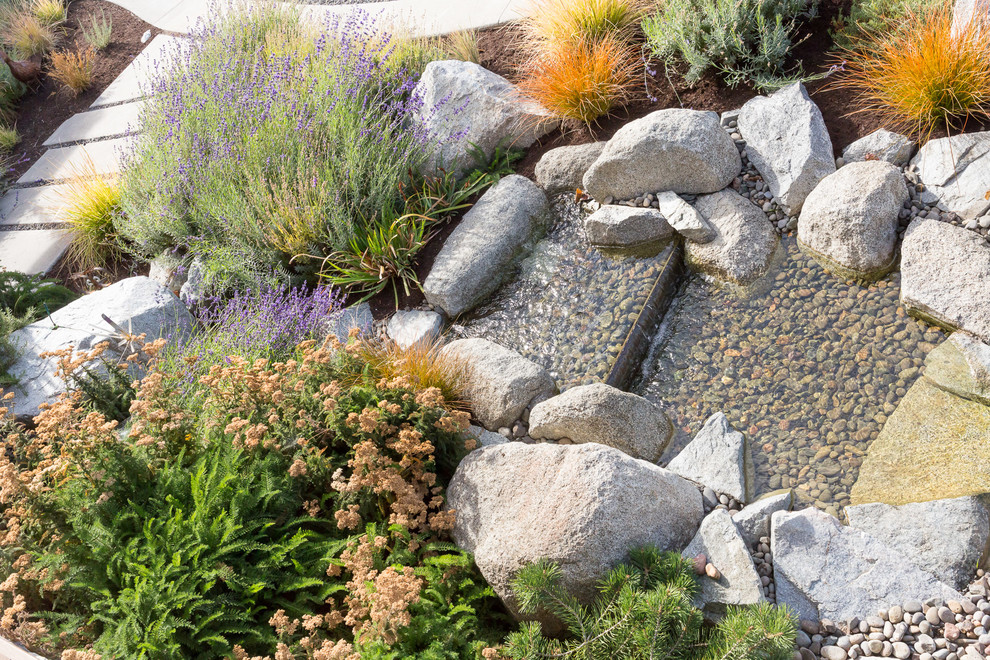 Design ideas for a large rustic drought-tolerant and full sun front yard gravel water fountain landscape.