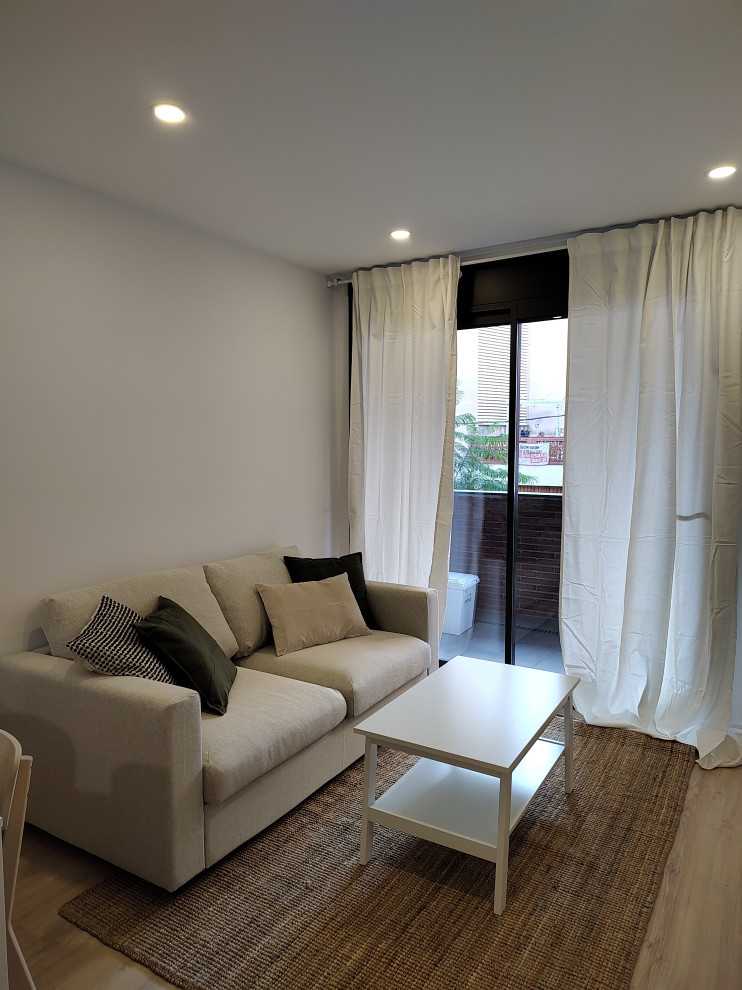 Idee per un soggiorno scandinavo di medie dimensioni e aperto con pareti bianche, parquet chiaro, TV autoportante, pavimento marrone e tappeto