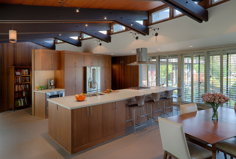 Photo of a large midcentury single-wall eat-in kitchen in San Francisco with an undermount sink, flat-panel cabinets, medium wood cabinets, quartz benchtops, vinyl floors, with island, stainless steel appliances and beige floor.